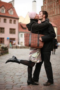 Young couple kissing in an old european town square.